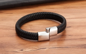 Gros plan du bracelet en cuir noir tressé pour hommes avec fermoir magnétique en métal brossé