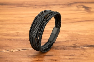 Macro view of multi-layer black braided leather bracelet with matte magnetic metal clasp