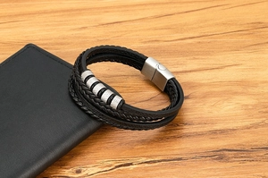 Détail du bracelet multicouche en cuir tressé noir avec perles métalliques argentées