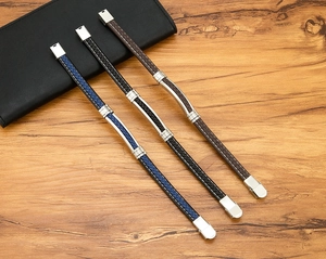 Detail van gevlochten leren armbanden met magnetische roestvrijstalen sluitingen op tafel