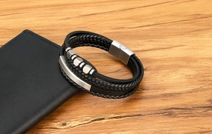 Detailansicht eines mehrlagigen Lederarmbands mit Stahlperlen auf einer Geldbörse