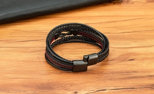 Dettaglio del bracciale multistrato da uomo in pelle con cuciture rosse e fibbia nera