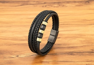 Détail du bracelet multicouche en cuir tressé noir avec fermoir magnétique doré et noir