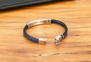 Detailweergave van zwart en blauw gevlochten leren armband met roestvrijstalen sluiting