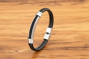 Detail van de zwart gevlochten lederen armband met een gepolijste roestvrijstalen plaat