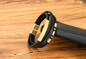 Nahaufnahme eines Herren-Lederarmbands mit goldenem Magnetverschluss auf Holzoberfläche