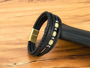 Detalle de pulsera multicapa de cuero para hombre con cierre magnético dorado y cuentas