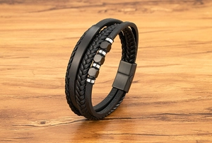 Makroaufnahme des mehrlagigen schwarzen Lederarmbands mit gebürsteter Metallplatte und Magnetverschluss