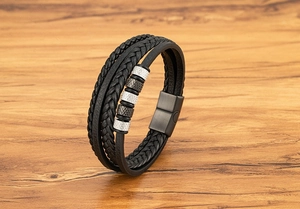 Détail du bracelet multicouche en cuir noir avec perles métalliques texturées et fermoir magnétique