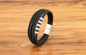 Détail d'un bracelet pour homme en cuir tressé noir multicouche avec perles en métal moleté