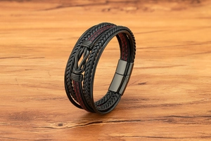 Dettaglio ravvicinato del bracciale in pelle multistrato con cuciture rosse e chiusura magnetica