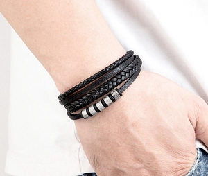 Détail d'un bracelet multicouche en cuir noir tressé pour homme avec perles argentées