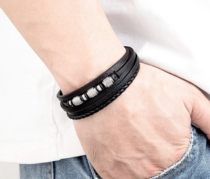 Primer plano de pulsera multicapa de cuero negro para hombre con cuentas de acero plata