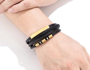 Nahaufnahme eines 4-lagigen Lederarmbands mit gold- und silberfarbenen Perlenakzenten