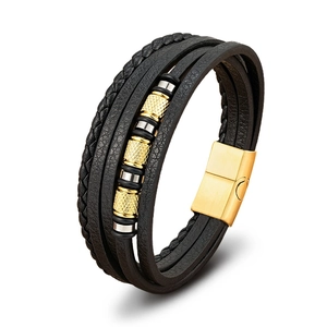 Detalle de pulsera multicapa de cuero trenzado negro con cierre magnético dorado y cuentas