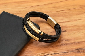 Detail eines mehrlagigen Lederarmbands mit magnetischem Metallverschluss in Gold