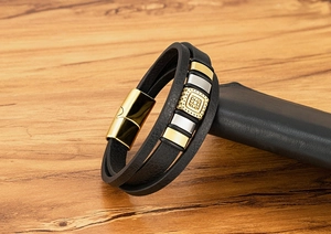 Dettaglio del bracciale in pelle multistrato con cubi dorati e chiusura magnetica