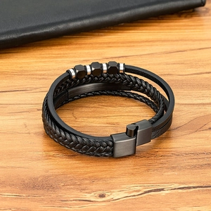 Mehrlagiges schwarzes Lederarmband für Herren mit geometrischen Perlen auf Holzgrund