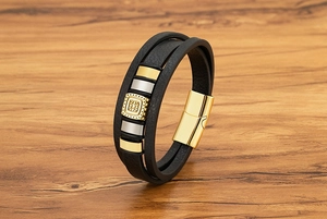 Dettaglio macro del bracciale multistrato in pelle nera da uomo con fibbia quadrata dorata