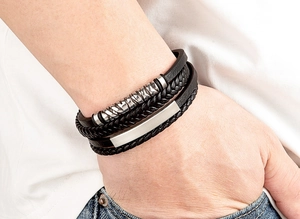 Details eines mehrlagigen Herren-Lederarmbands in Schwarz mit silbernen Metallrohren