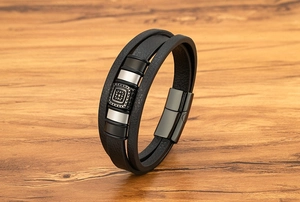 Dettaglio del bracciale in pelle multistrato da uomo con perle geometriche e chiusura magnetica