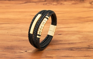 Nahaufnahme von mehrlagigem Herrenarmband aus schwarzem Leder mit goldener Magnetschließe