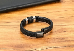 Close-up of a black braided leather bracelet with stainless steel accents and magnetic clasp.