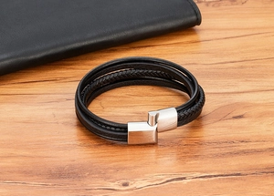 Detail view of multi-layer braided black leather bracelet with silver magnetic clasp
