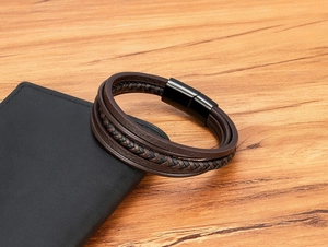 Close-up of multilayer braided leather bracelet with black magnetic clasp on desk