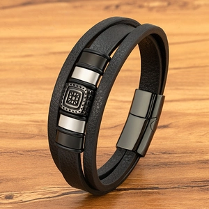 Bracciale multistrato da uomo in pelle nera con fibbia vintage quadrata su fondo legno