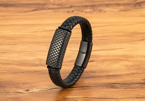 Macro detail of men's black braided leather bracelet with magnetic grid metal clasp