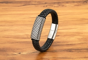 Close-up of a men's woven leather bracelet featuring a silver metal diamond pattern clasp