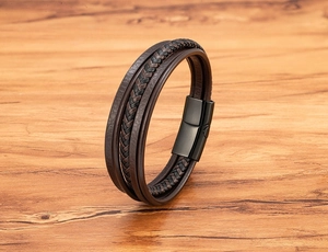 Detail shot of multi-layer braided leather wristband with matte black magnetic buckle