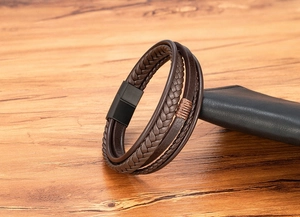 Detail of multi-layer brown braided leather bracelet with black matte magnetic metal clasp