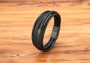Detail of men's multi-layer black braided leather bracelet with matte magnetic clasp