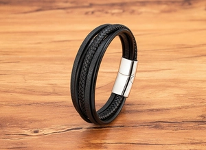 Macro detail of multi-layer black leather bracelet with silver polished magnetic clasp