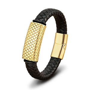 Detail of black braided leather bracelet with golden grid textured metal accent and clasp