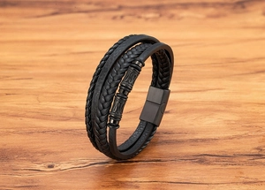 Detalle de una pulsera multicapa de cuero trenzado negro con cierre magnético mate