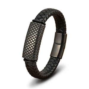 Detail of men's black braided leather bracelet with gray geometric textured metal buckle