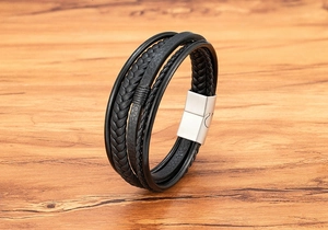 Detail view of multi-layer black leather woven bracelet with silver magnetic metal clasp