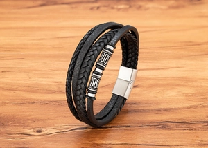 Detalle de pulsera de cuero de triple capa para hombre con cuentas plateadas y cierre magnético