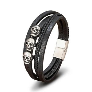 Detailansicht eines mehrlagigen Lederarmbands für Herren mit Totenkopf-Anhängern im Punk-Stil