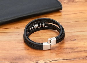Close-up of multilayer leather bracelet featuring stainless steel clasp and skull beads
