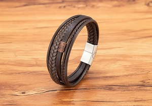 Macro shot of multi-layer brown leather woven bracelet with brushed metal magnetic clasp