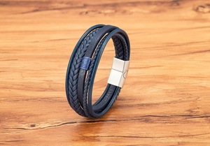 Close-up of multilayer braided blue leather bracelet with metallic magnetic clasp on wood