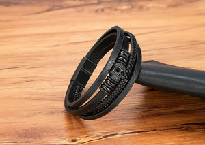 Macro shot of a black multilayer leather skull bracelet with a black magnetic steel clasp