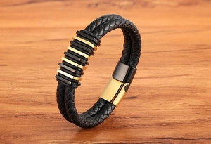 Dettaglio del bracciale da uomo in pelle intrecciata a doppio giro con chiusura dorata