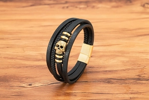 Detailed close-up of multi-layer leather bracelet with golden skull and magnetic clasp