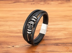 Close-up of multilayer leather bracelet with skull charm and silver magnetic buckle
