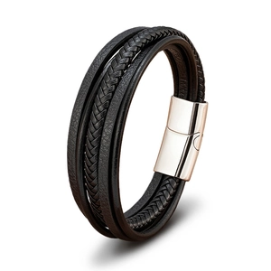 Detail of multi-layer black leather bracelet featuring woven textures and polished magnetic clasp